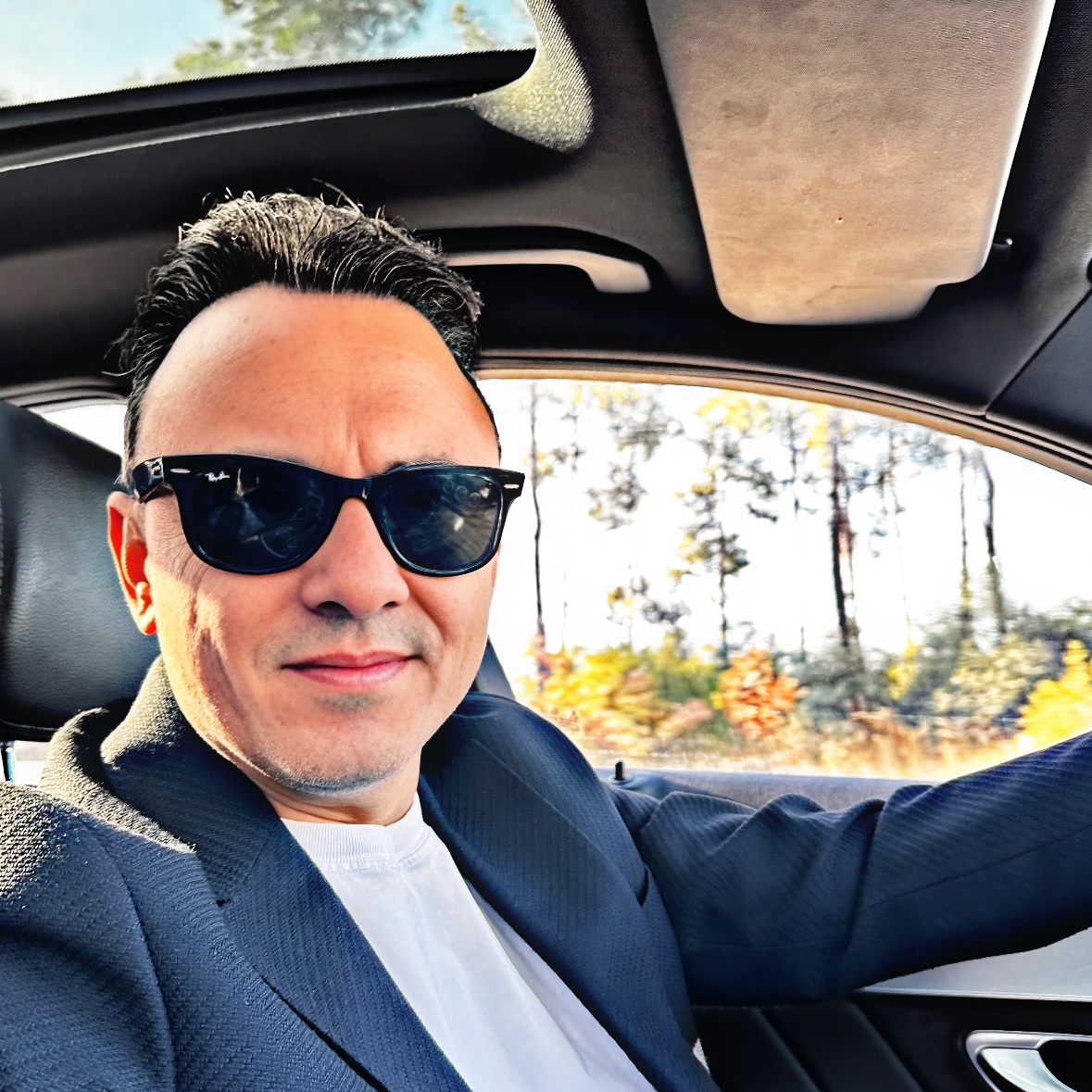 Fatih Şebin’in güneş gözlüklü, lacivert ceketli araç fotoğrafı